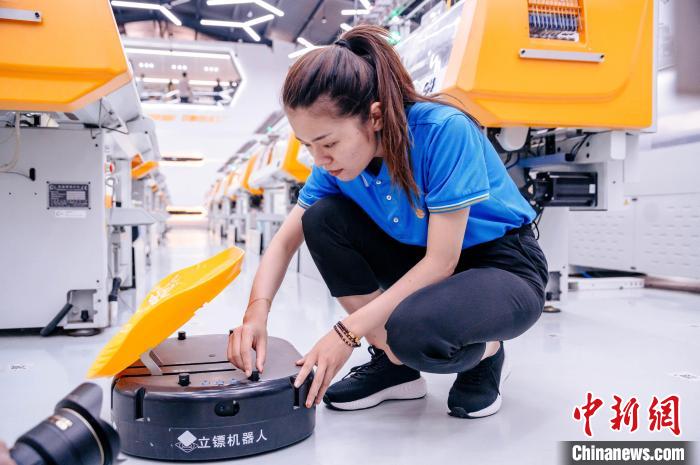 圖為員工在調(diào)試AGV搬運機器人。　李南軒 攝